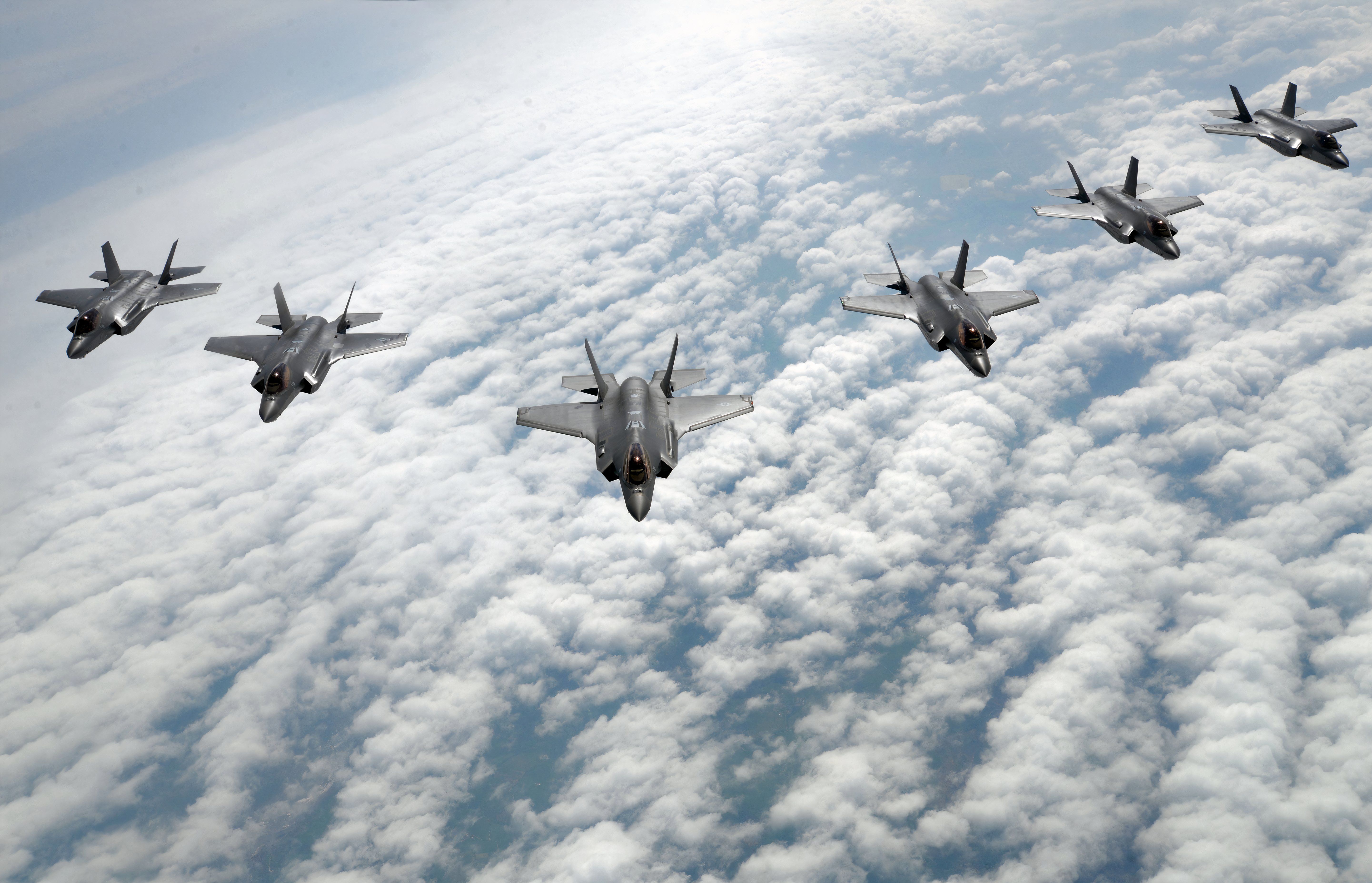 F-35's flying in formation above the clouds.