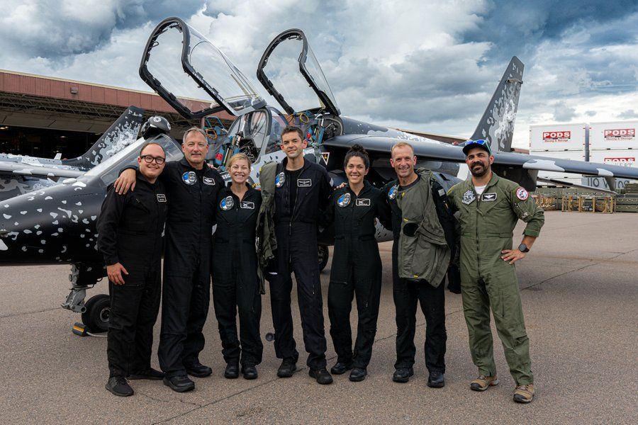 Polaris team pose by jet trainer