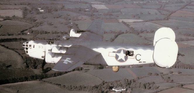 SB-24 flying over the countryside in 1943, with the radar pod visible on the plane's underside.