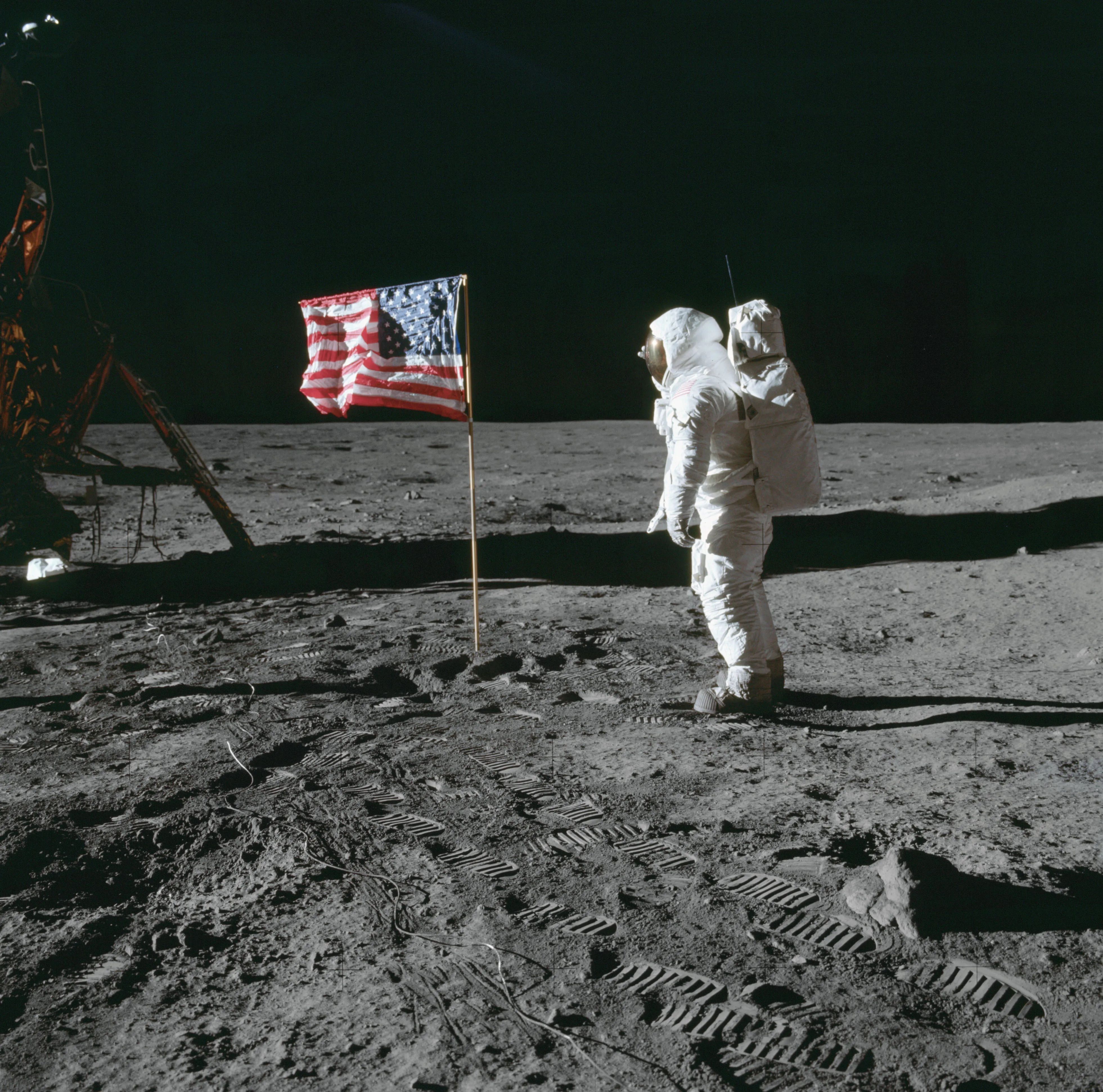 Photo of Buzz Aldrin posing beside the American flag on the moon.