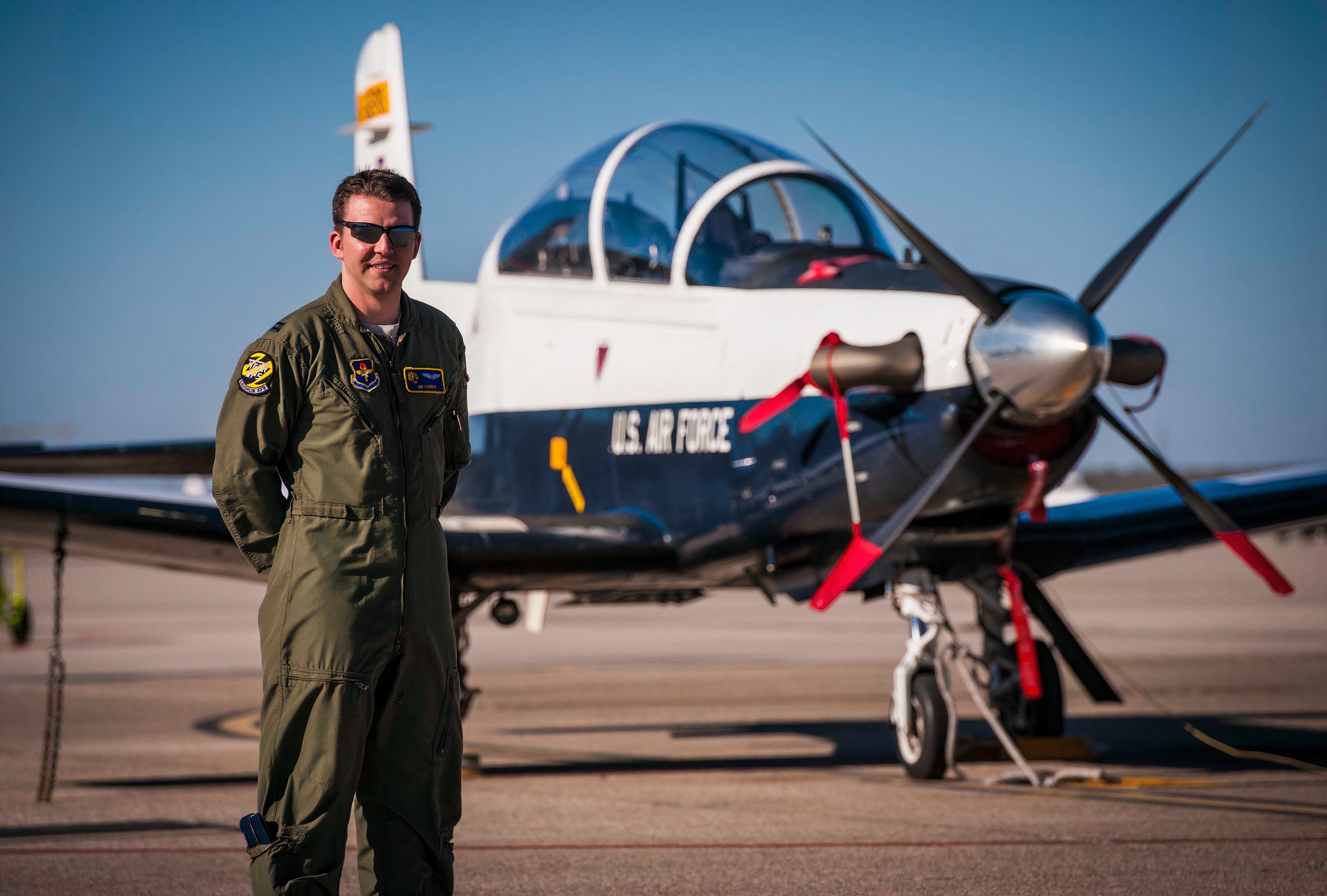 Pilot standing next to a parked airplane.