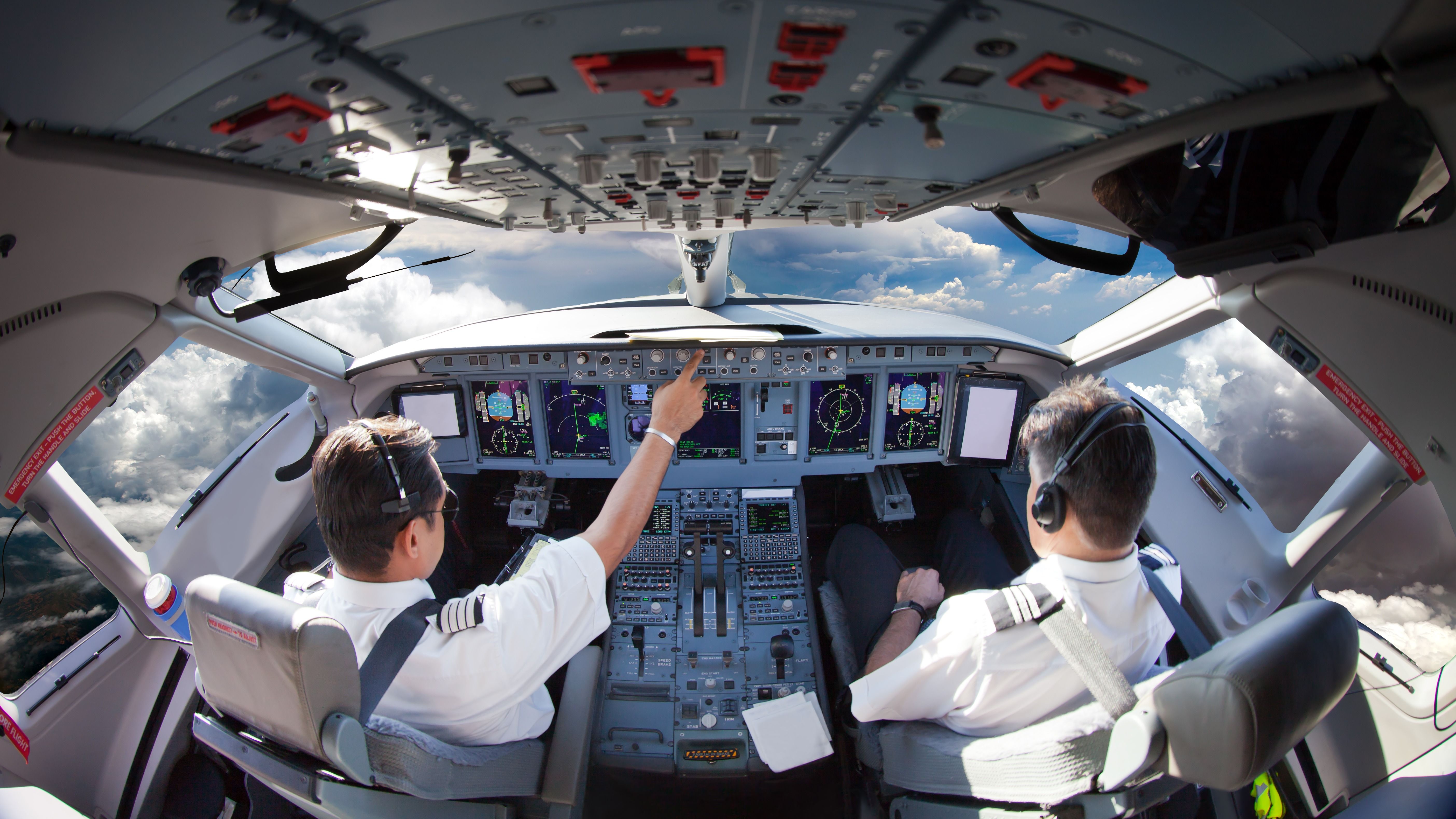 Flight Deck of modern aircraft. Pilots at work. Clouds view from the plane cockpit.