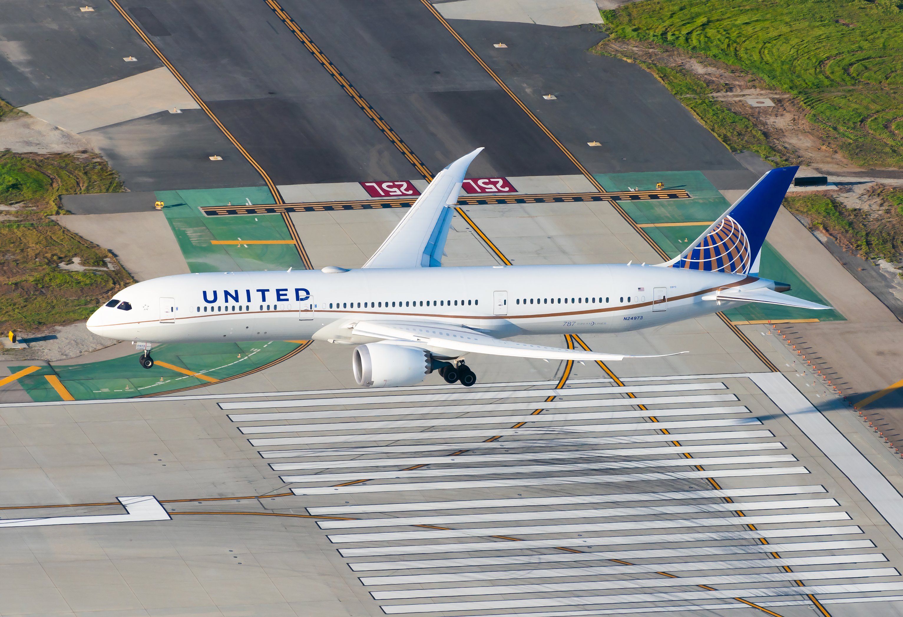 Los Angeles, CA / USA - February 15 2020: United Airline Boeing 787 Dreamliner on final approach LAX International Airport. Aerial view of 787-9 aircraft registered as N24973 over runway threshold.