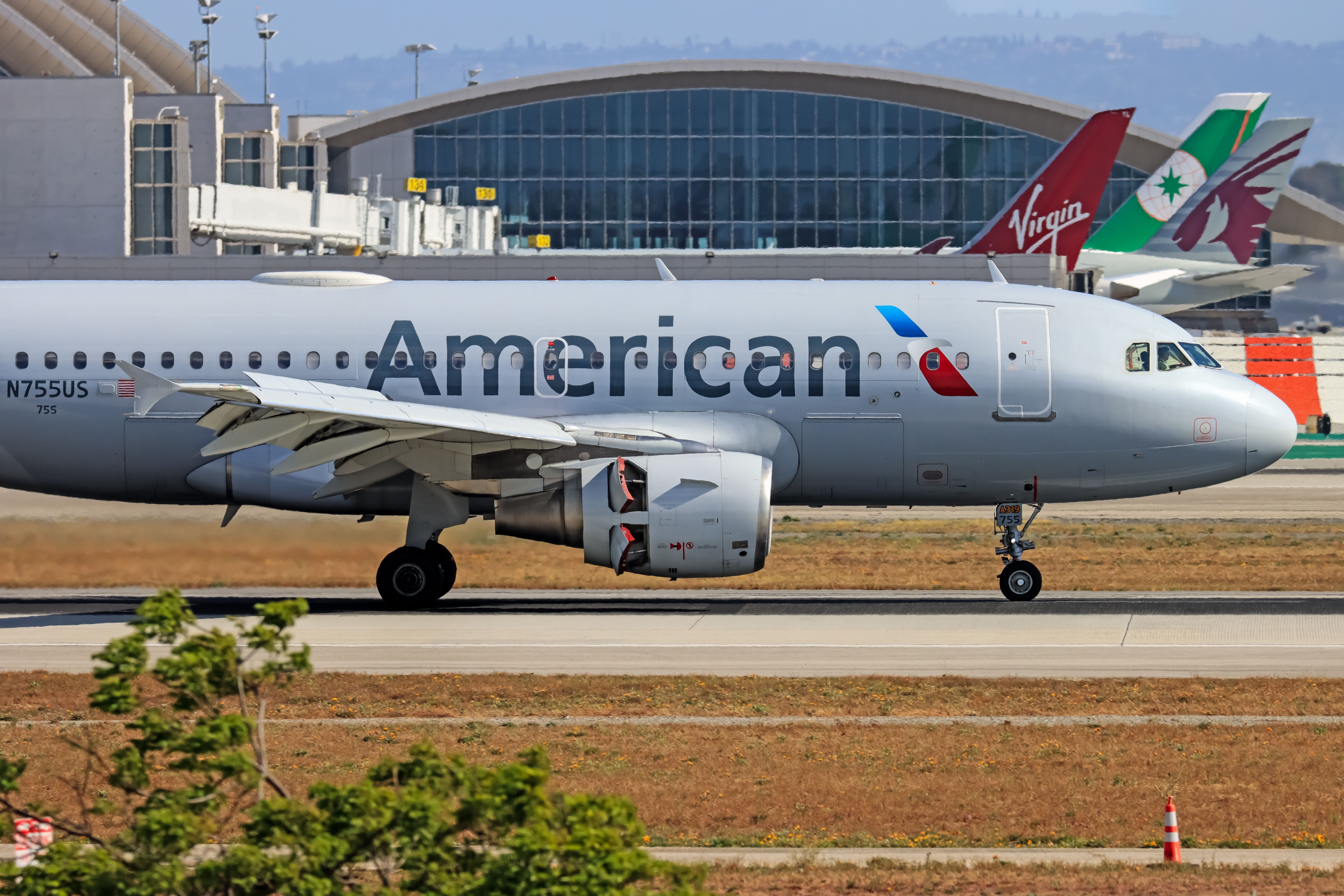 An American Airlines Airbus A319, registration number is N755US, Landing at Los Angeles (LAX) in front of planes from Eva Air, Virgin Atlantic, and Qatar Airways