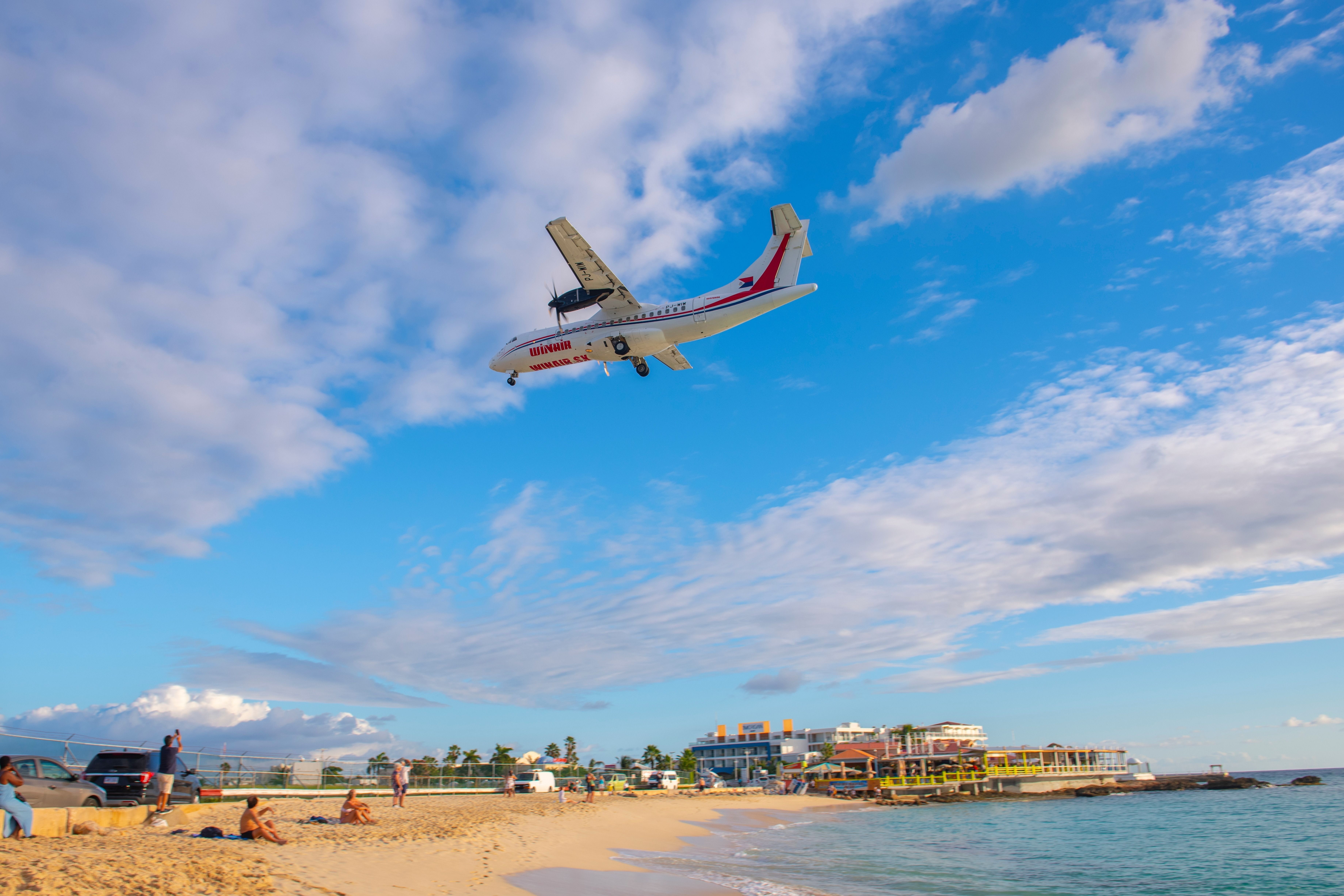  Winair (Windward Islands Airways) ATR 42 flying over Maho Beach before landing on Princess Juliana International Airport SXM on Sint Maarten, Dutch Caribbean.