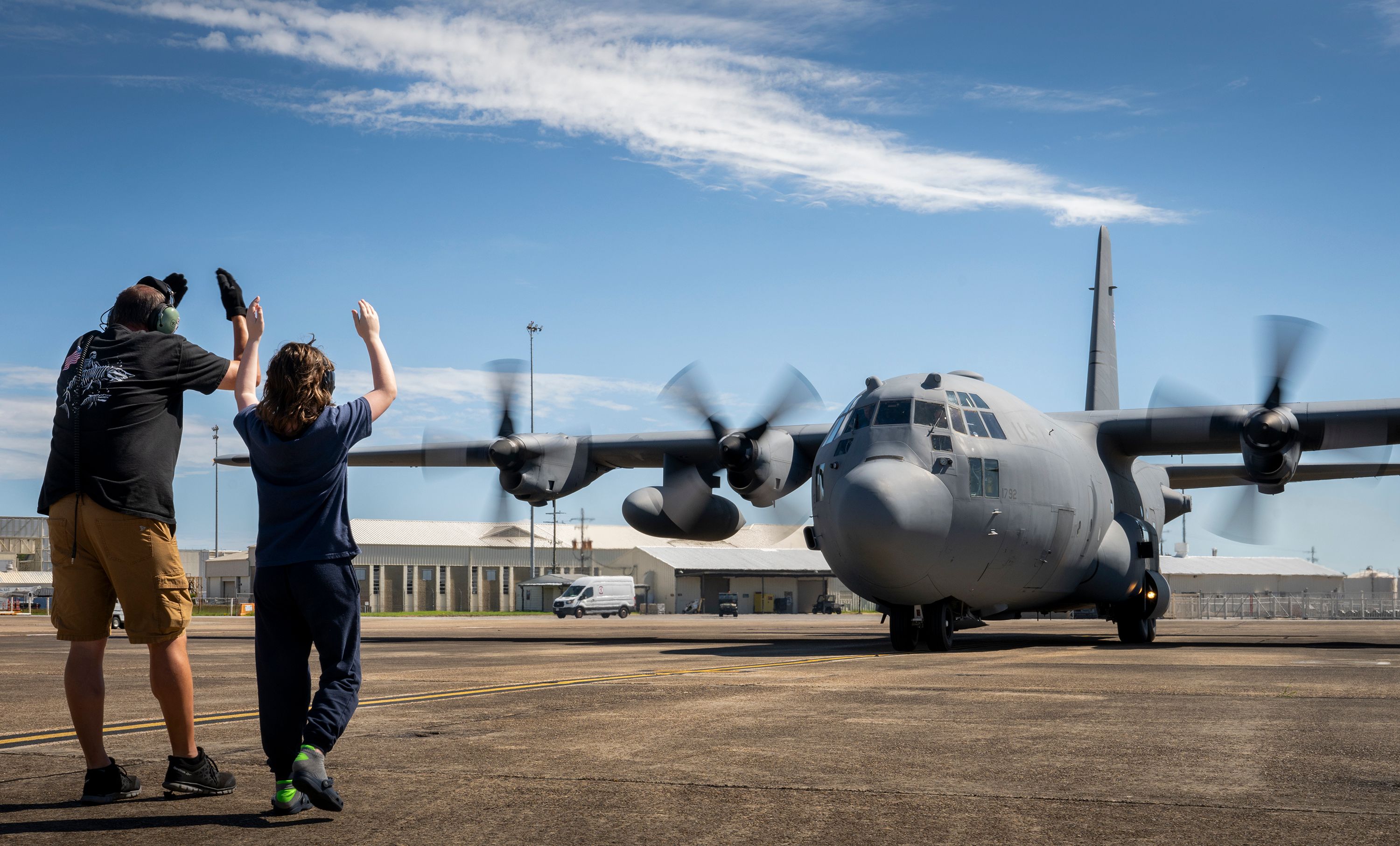 A 96th Test Wing maintainer helps 11-year-old Anthony Lindstrom marshal in his grandfather and pilot, Gary Hogg,