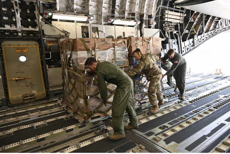 Crew loading supplies onto an aircraft.