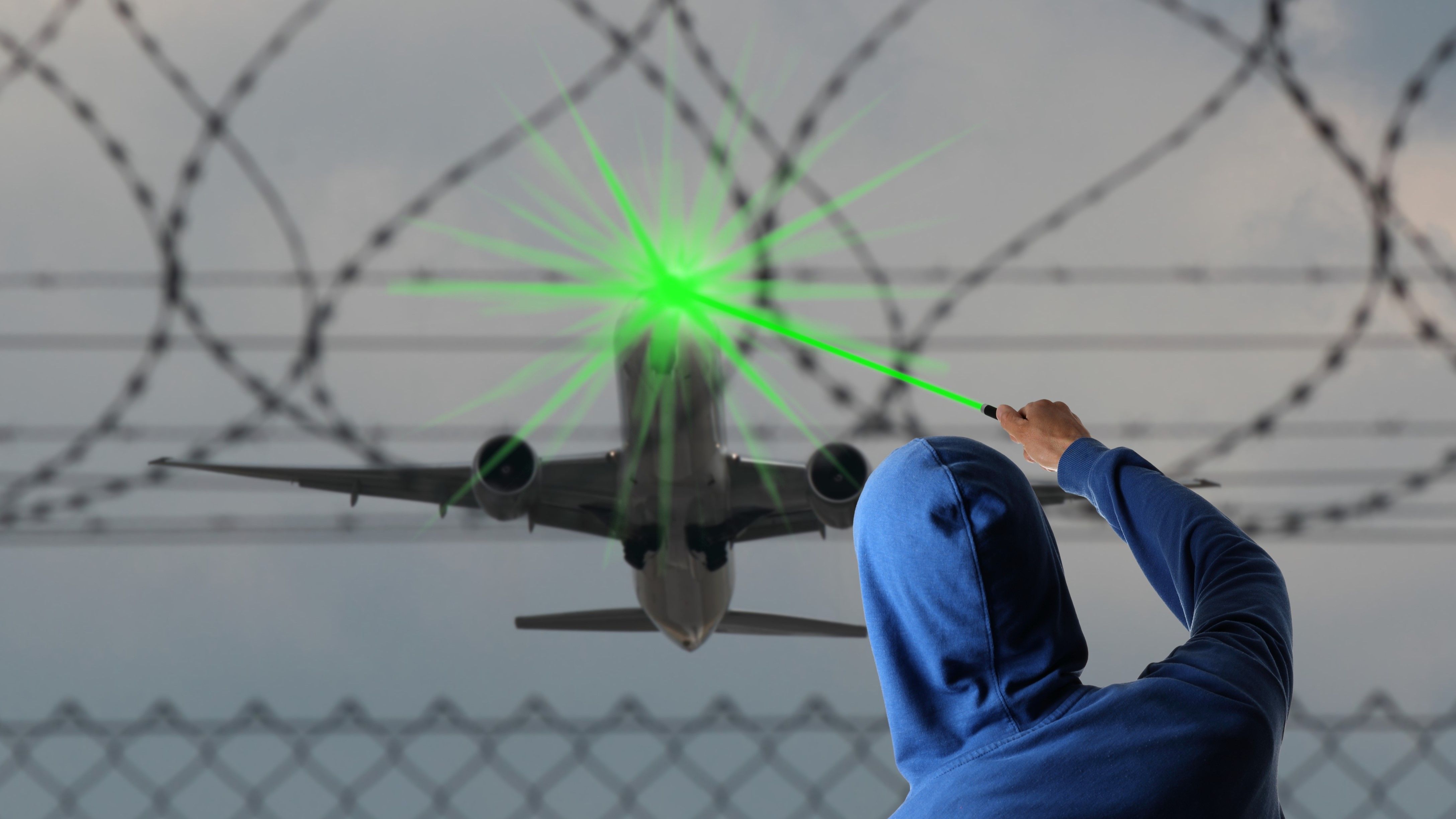 Rendering Of A Hooded Individual Shining A Green Laser At A Departing Airplane
