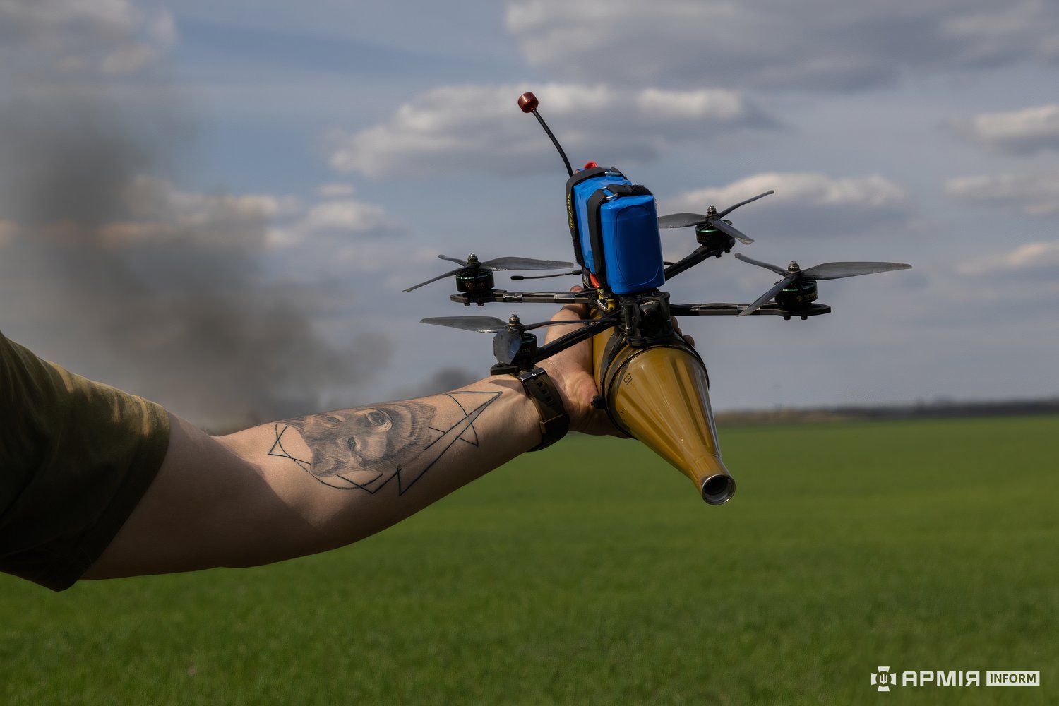 Photo of a soldier holding a drone with an RPG warhead attacked to its underside