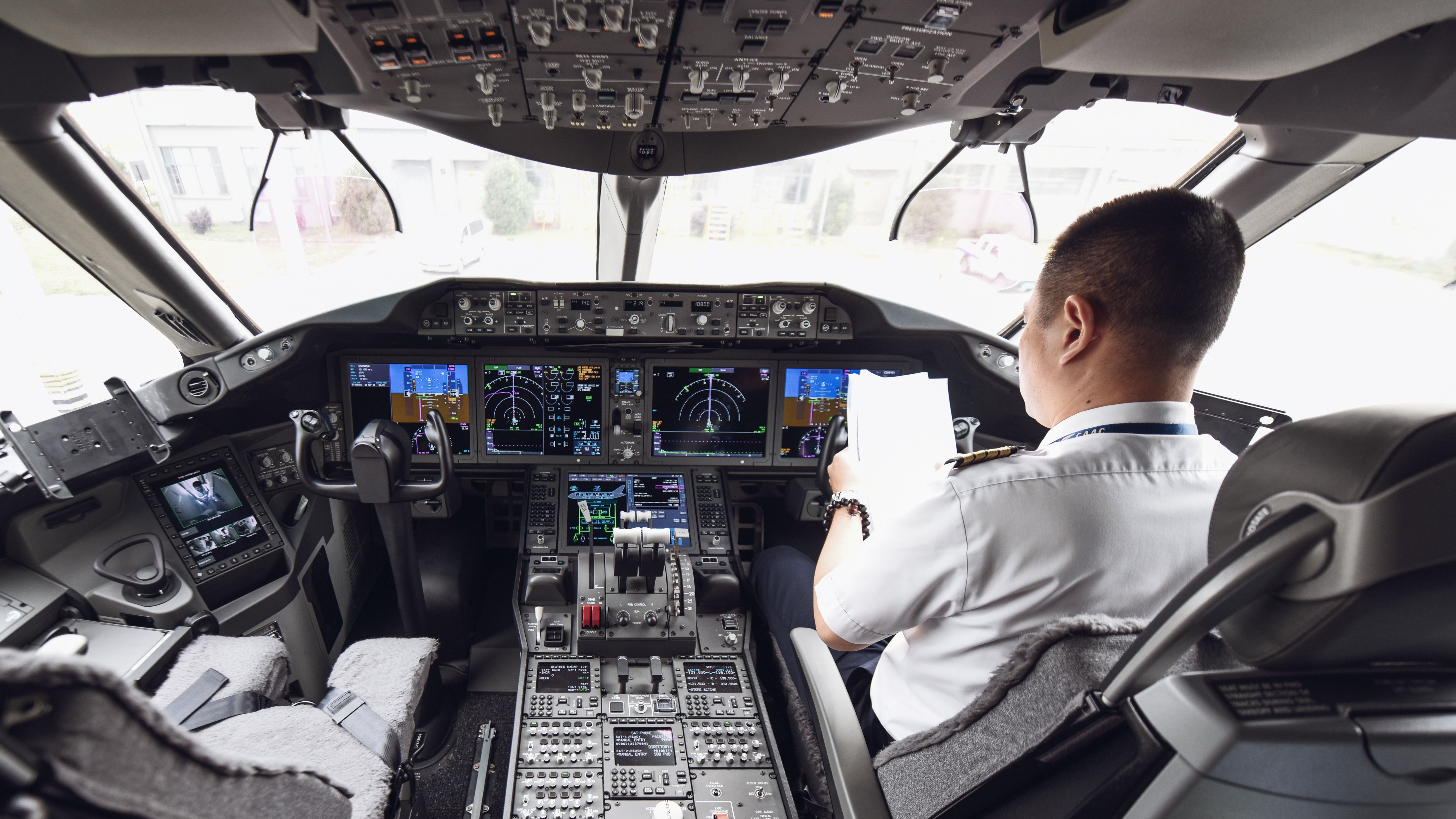 Boeing 787 cockpit with one pilot in it shutterstock_1189760212