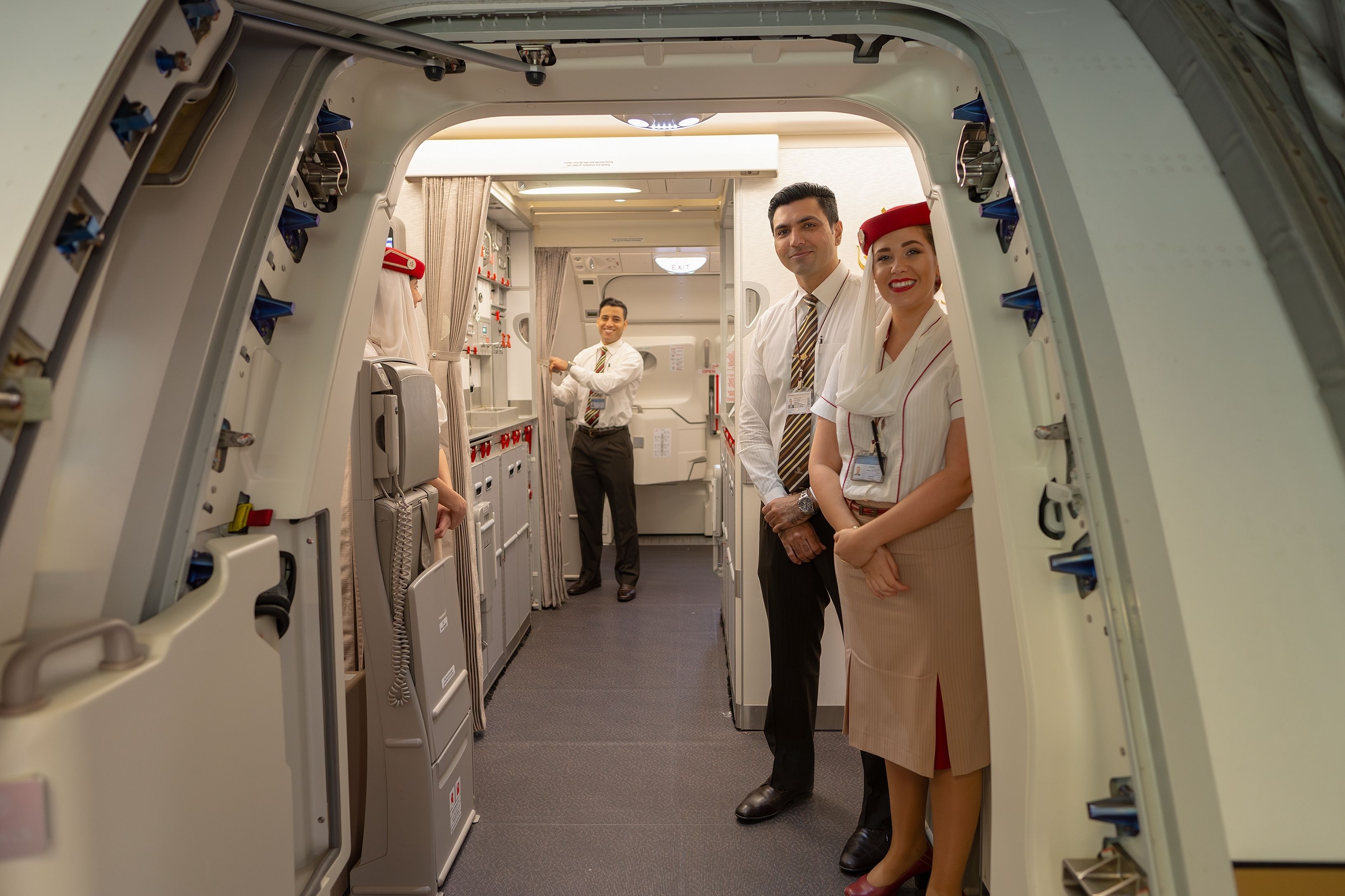 Emirates cabin crew welcoming passengers onboard an Airbus A380 shutterstock_2478859967