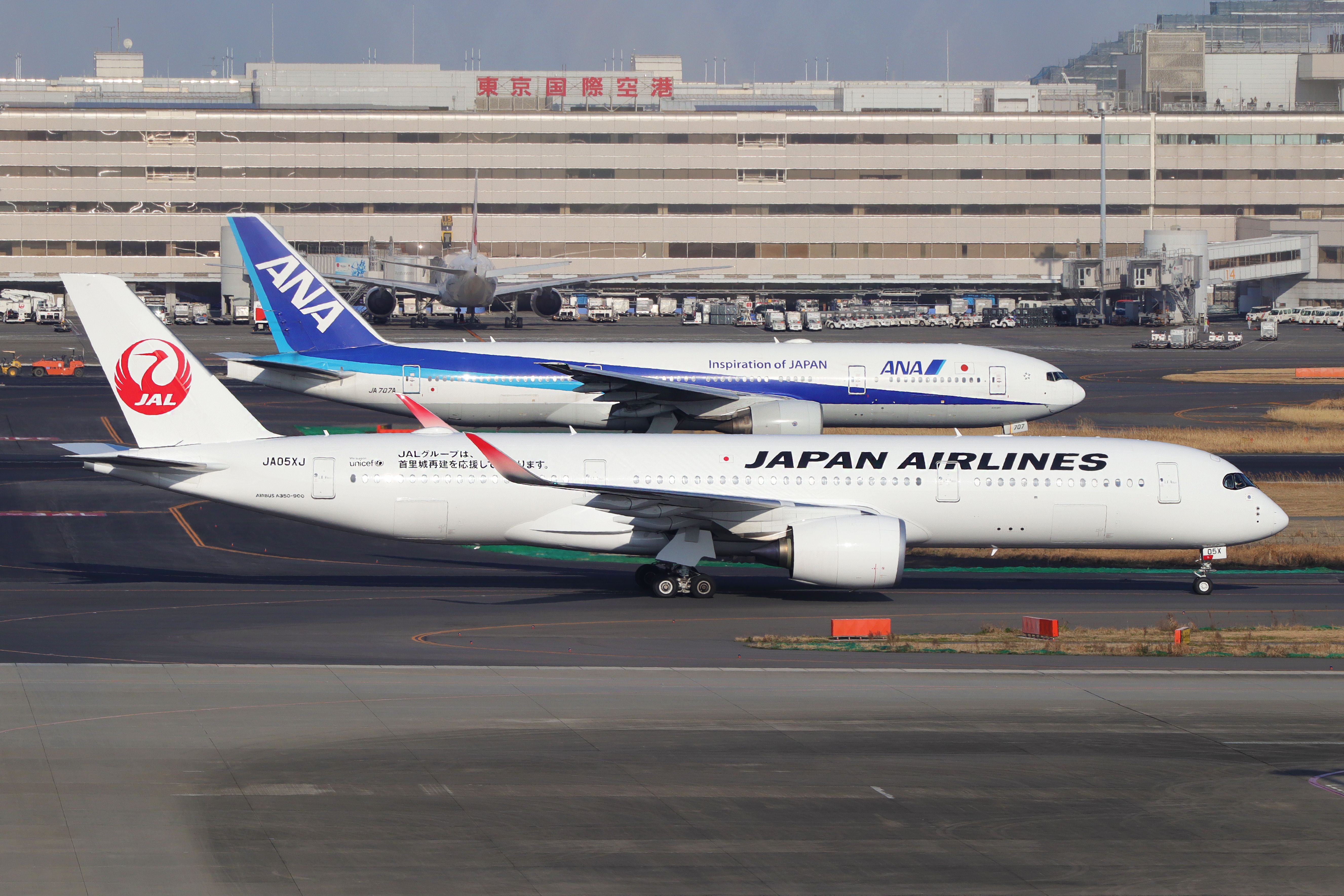 Japan Airlines Airbus A350-900 and ANA Boeing 777-300 at Tokyo Haneda Airport HND shutterstock_1692420436