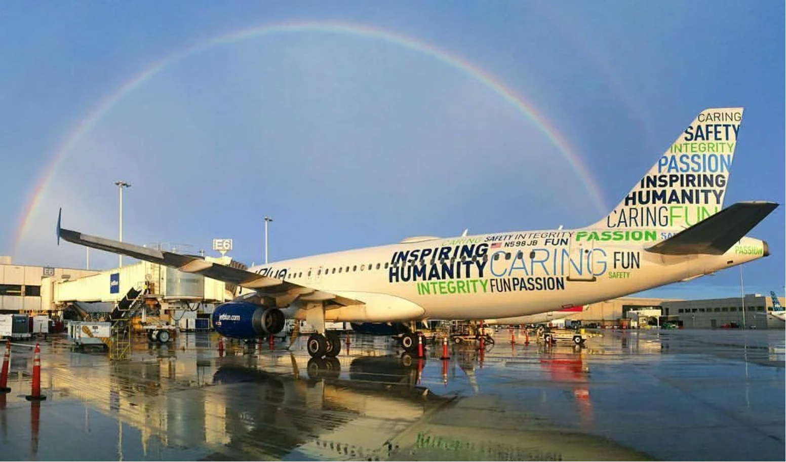 JetBlue aircraft parked under rainbow