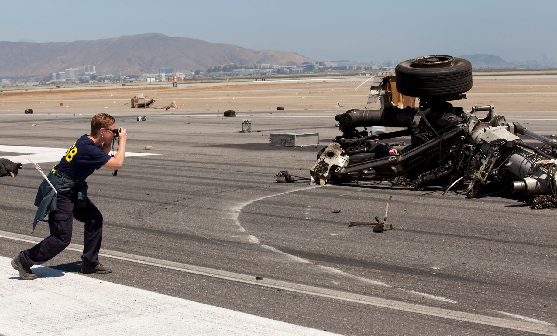 NTSB Investigator Courtney Liedler documents wreckage on the scene of the Asiana Airlines flight 214 crash in San Francisco, CA.