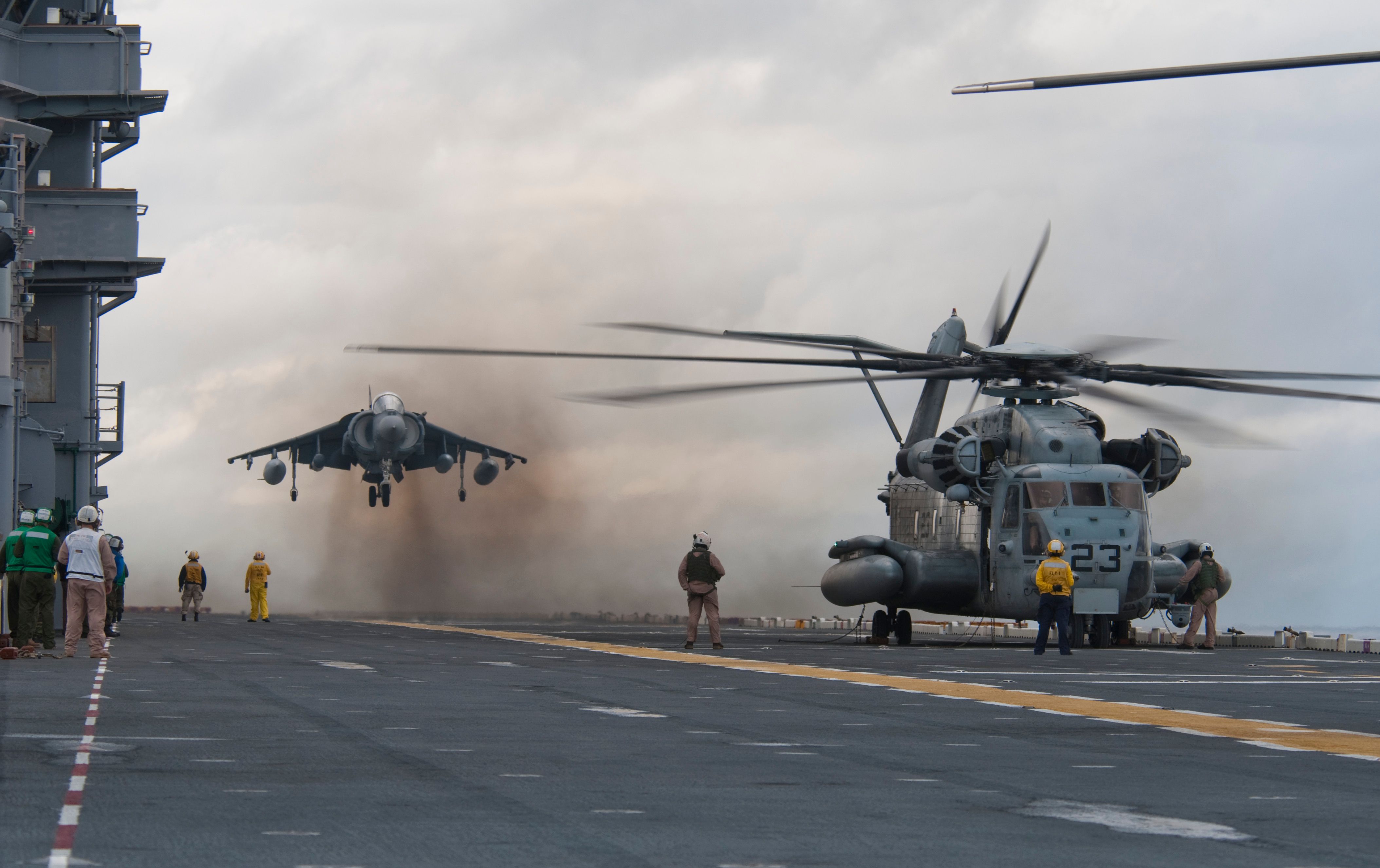 US_NAVY_091026-N-5319A-025_AN_AV-8_HARRIER_FROM_MARINE_MARINE_ATTACK_SQUADRON_（VMA）_223_lands_next_next_to_an_an_mh-5 3E_SEA_DRAGON_HELICOPTER_ABOARD_THE_AMPIBLION_ASSAULT_SHIP_SHIP_NASSAU_（LHA_4）_DURING_FLIGHT_OPERATIONS