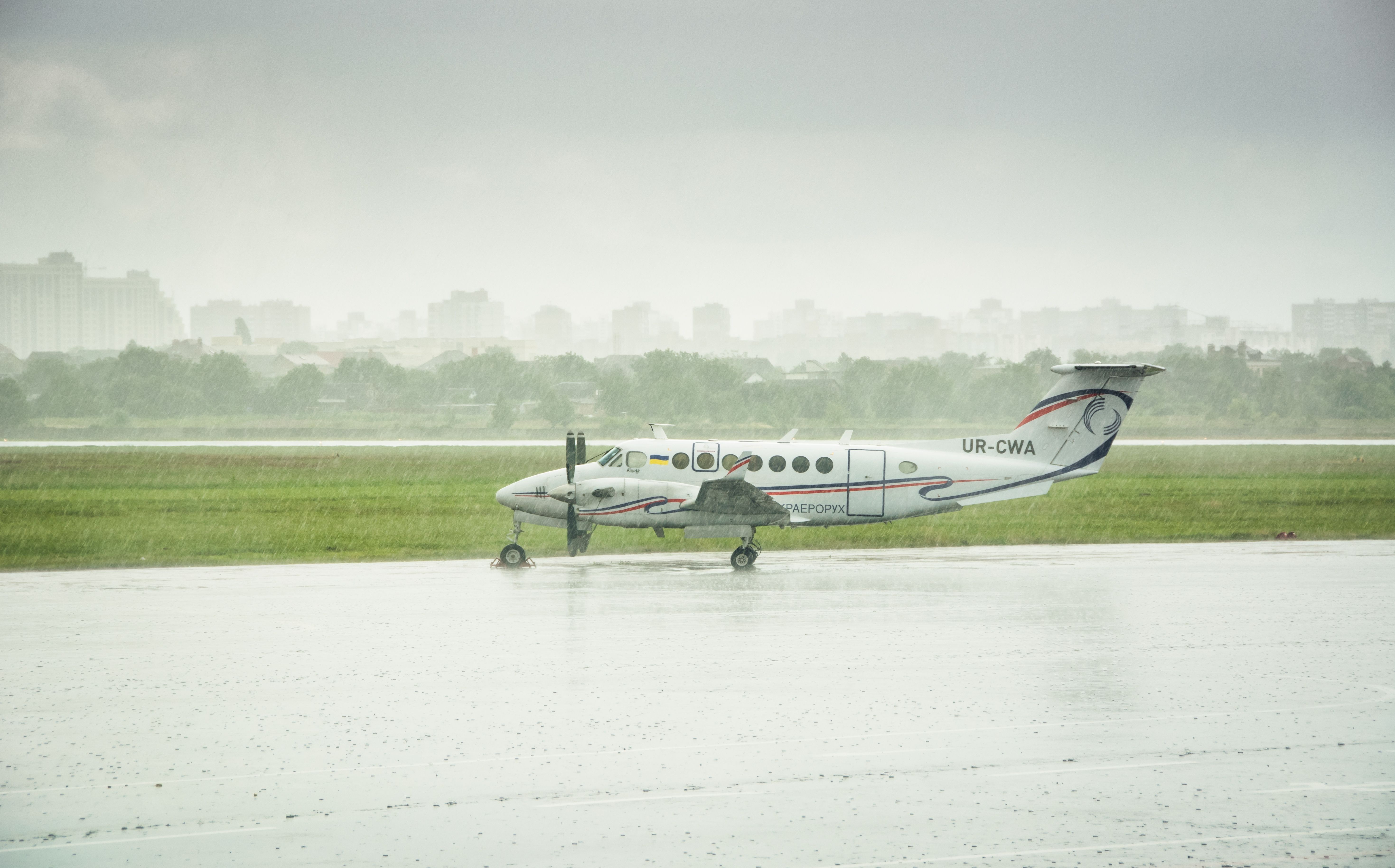 Beechcraft King Air (UR-CWA) on apron of Kyiv International Airport amid heavy rain.