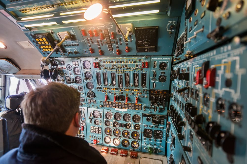 Close-up view of old large passenger aircraft cockpit. Flight engineer seating at engine control panel
