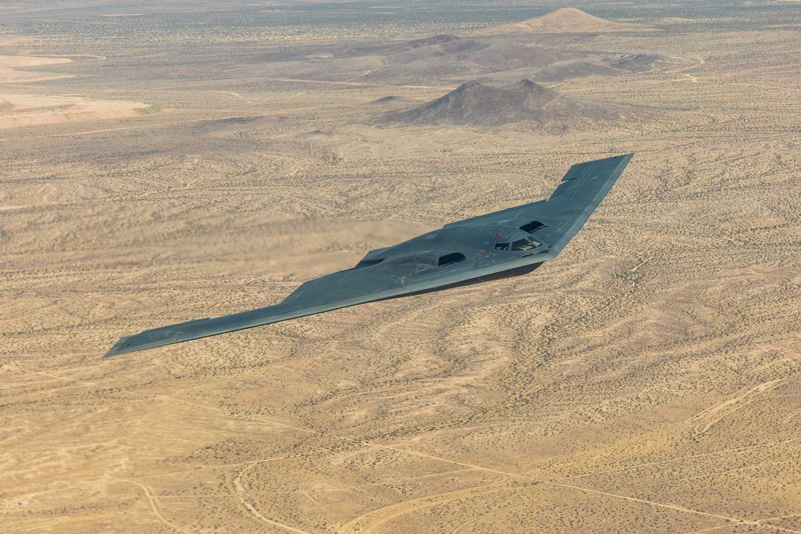 A B-2 Spirit soars over the Mojave Desert while proudly displaying an American flag on July 17, 2024.