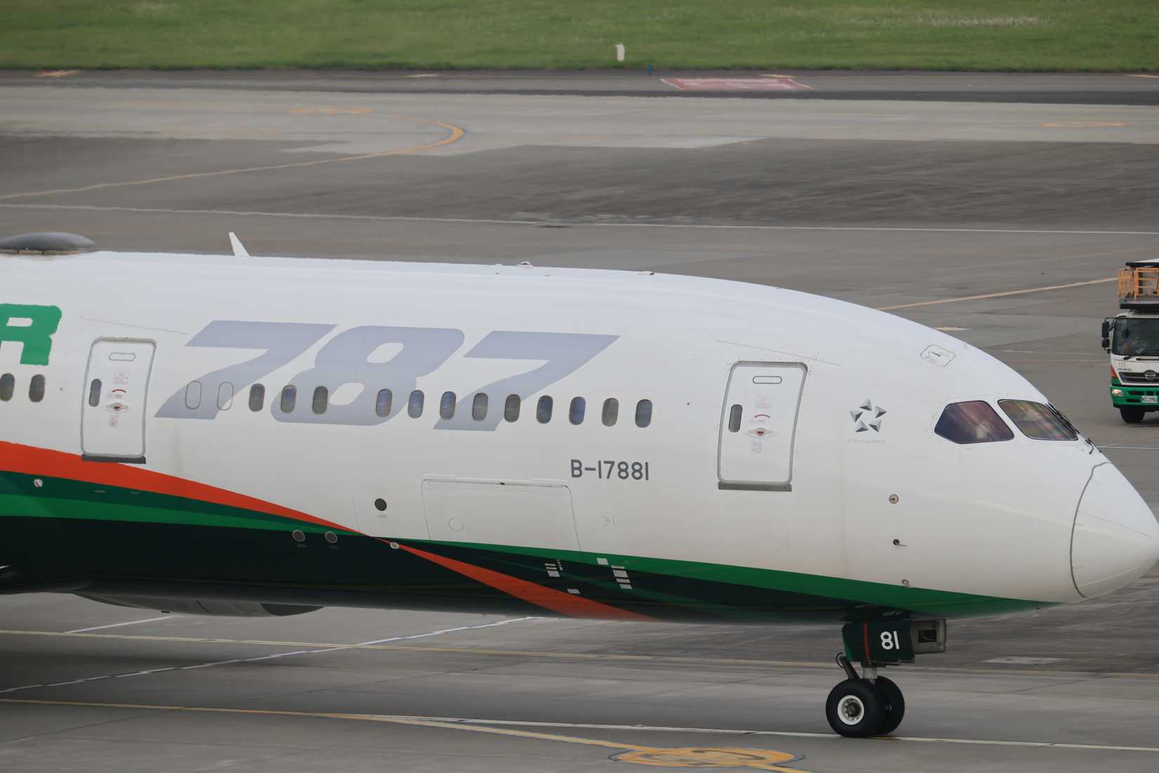 An EVA Air Boeing 787 Dreamliner taxiing at Taoyuan International Airport with another EVA Air aircraft partially visible in the foreground.
