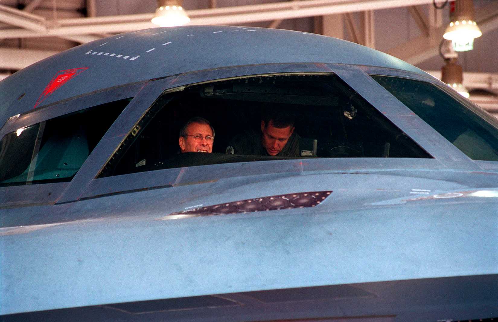 Secretary of Defense Donald H. Rumsfeld (left) peers out the windshield from the mission commander's seat of a U.S. Air Force B-2 Spirit bomber at Whiteman Air Force Base, Mo., on Oct. 19, 2001.