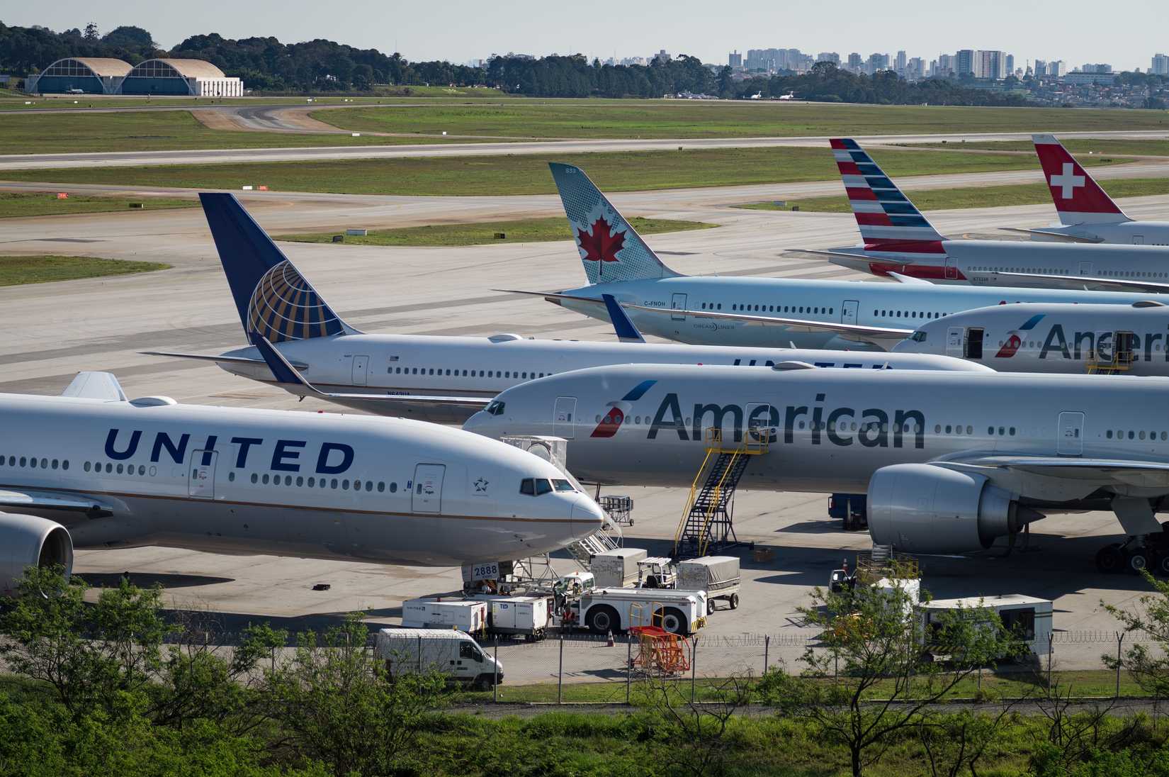 United Airlines, American Airlines, Air Canada and Swiss Airlines aircraft parked in parallel 