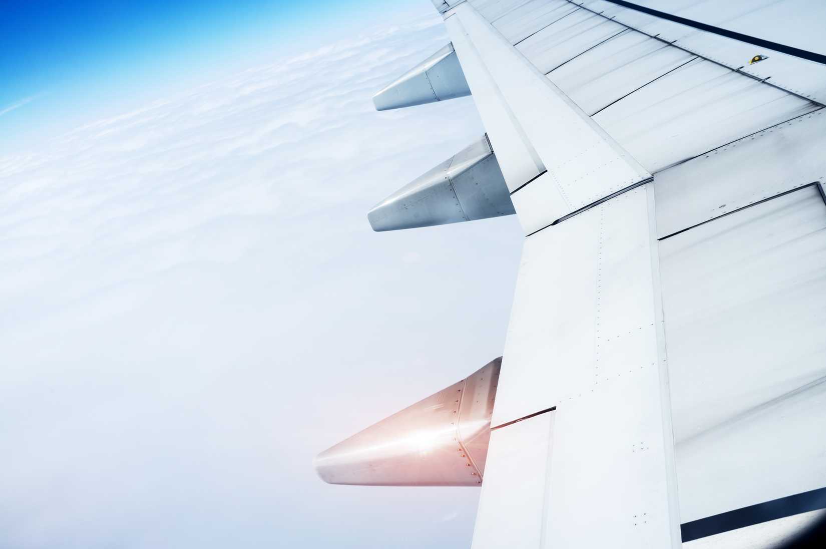 The plane's wings, the background is blue sky, taken from the cabin